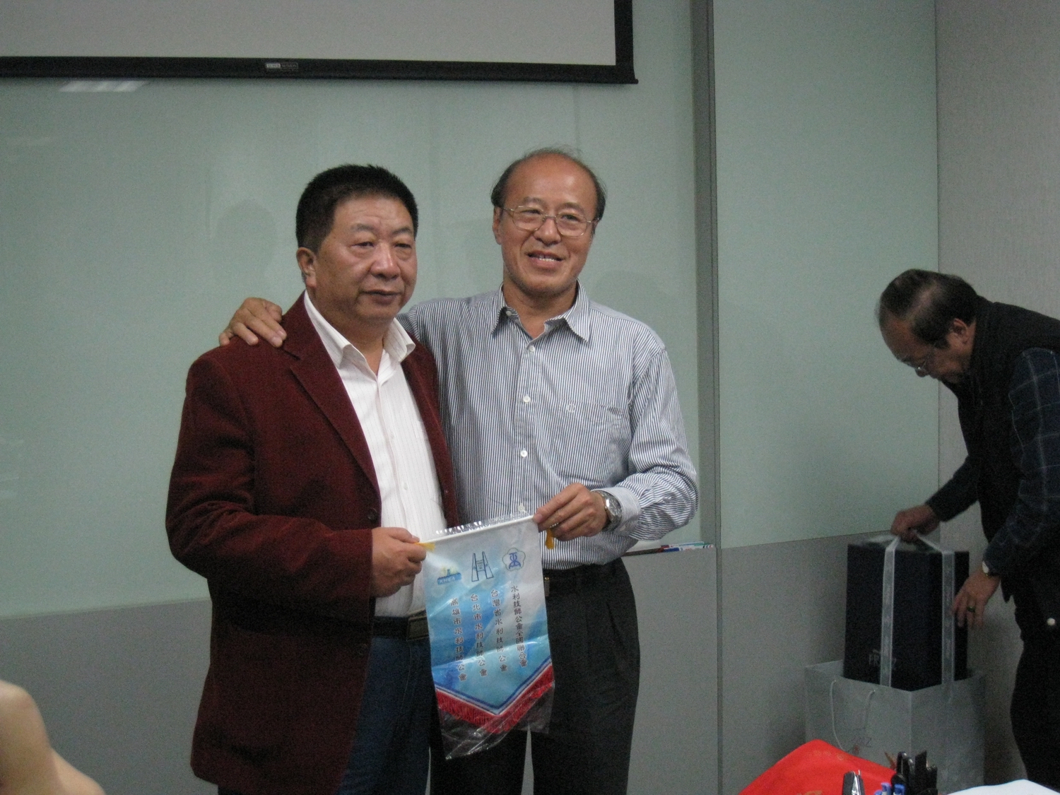 省公會周文祥理事長代表致贈會旗予學會代表柴建華副理事長。
